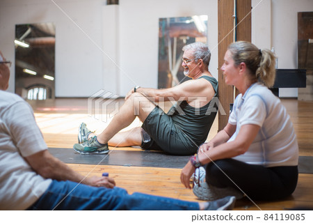 Smiling senior dance students resting on floor Smiling senior dance students resting on floor 84119085