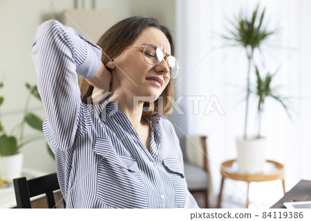 Freelancer young woman suffering with neck pain Freelancer young woman suffering with neck pain 84119386