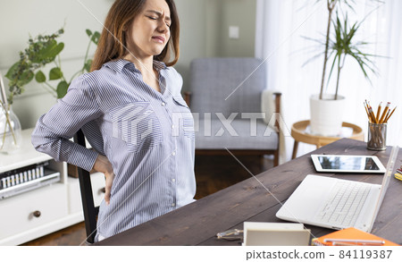 Freelancer young woman suffering with back pain Freelancer young woman suffering with back pain 84119387