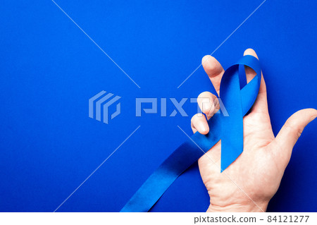 Prostate care. Awareness prostate cancer of men health in November. Blue ribbon in hands isolated on deep blue background. World cancer day and world diabetes day concept. 84121277