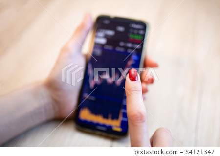 Women's hands investing in smartphones Women's hands investing in smartphones 84121342