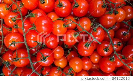 Lots of small and juicy scarlet cherry tomatoes on branches for sale in the farmers market Lots of small and juicy scarlet cherry tomatoes on branches for sale in the farmers market 84122013