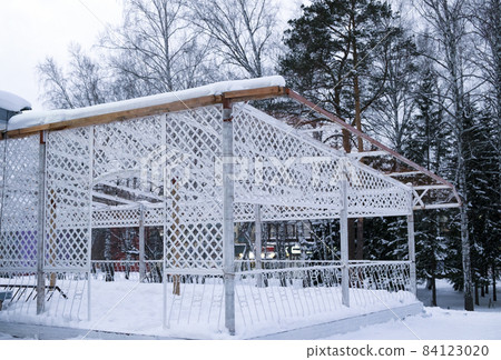 The open summer veranda of the restaurant is covered with snow, there are no people. Winter, snow, cold, frost 84123020