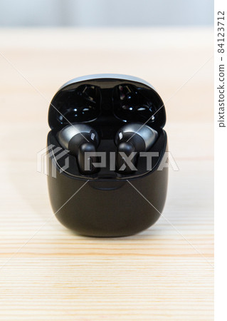 Wireless headphones in a compact black container, charger 84123712