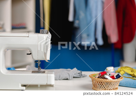 Electric sewing machine in a seamstress office 84124524