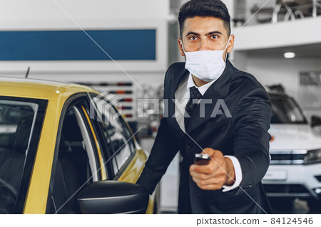 Man car dealer wearing protective medical mask on his working place 84124546