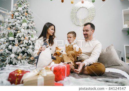 Smiling parents giving Christmas present to son at home 84124547
