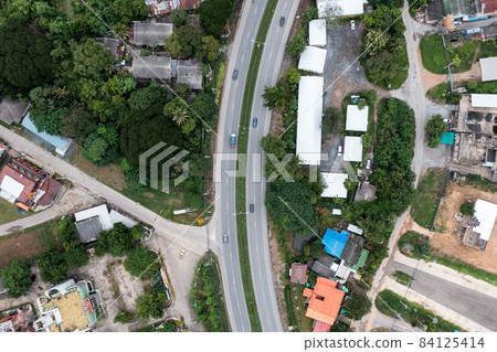 Curved road and car driving through suburban town Curved road and car driving through suburban town 84125414