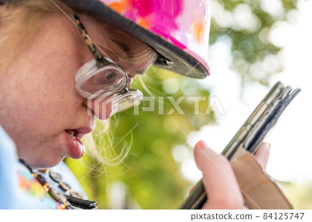 Portrait of a 39 year old white woman with Down Syndrome, calling her family on the phone Portrait of a 39 year old white woman with Down Syndrome, calling her family on the phone 84125747