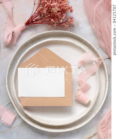 Card with envelope on plate with pink flowers and ribbons Card with envelope on plate with pink flowers and ribbons 84125787