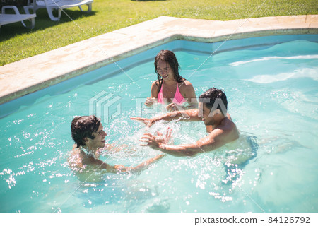 Cheerful friends swimming in pool Cheerful friends swimming in pool 84126792