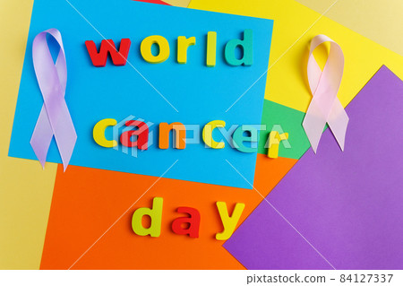 Text World Cancer Day ribbon on a multicolored surface background. Top view Text World Cancer Day ribbon on a multicolored surface background. Top view 84127337
