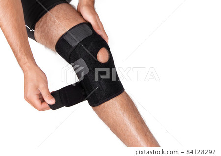 Knee Support Brace on leg isolated on white background. Orthopedic Anatomic. Braces for knee fixation, injuries and pain. Knee Joint Bandage Sleeve. Elastic Sports. 84128292