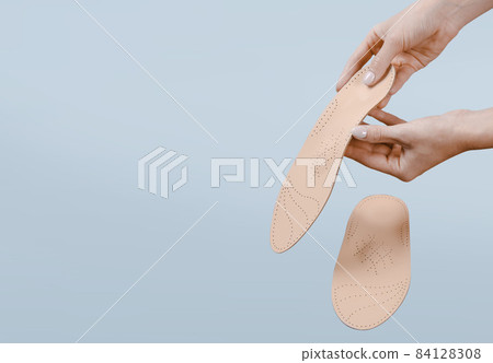 Orthopedic insole isolated on a blue background. Medical insoles. Treatment and prevention of flat feet and foot diseases. Foot care, feet comfort. Wear comfortable shoes. Flat Feet Correction. Orthopedic insole isolated on a blue background. Medical insoles. Treatment and prevention of flat feet and foot diseases. Foot care, feet comfort. Wear comfortable shoes. Flat Feet Correction. 84128308