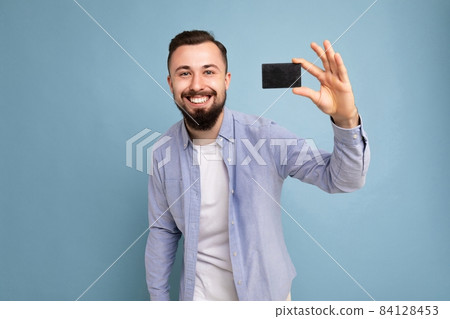 Photo of good looking attractive positive happy smiling brunet unshaven young man wearing casual 84128453