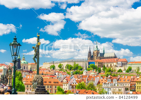 Crucifix and Calvary statue on Charles Bridge Karluv Most over Vltava river with Prague Castle 84128499