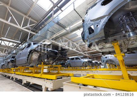 Car bodies are on assembly line. Factory for production of cars. Modern automotive industry 84128616