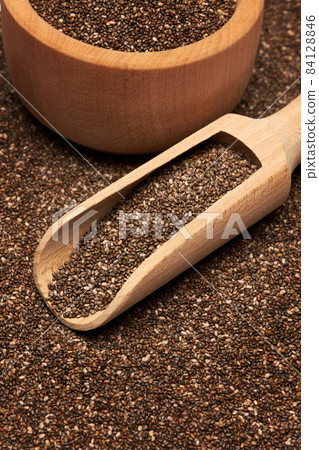 Organic natural chia seeds, wooden scoop and bowl close-up Organic natural chia seeds, wooden scoop and bowl close-up 84128846