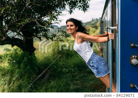 The girl travels by train to beautiful places. Beautiful girl traveling by train among mountains. Travel by train. Travelling to Asia. Trains Sri Lanka. Railway transport. Railway. Transport Asia The girl travels by train to beautiful places. Beautiful girl traveling by train among mountains. Travel by train. Travelling to Asia. Trains Sri Lanka. Railway transport. Railway. Transport Asia 84129071