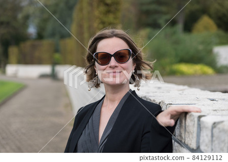 Portrait of thirty year old woman with sunglasses, posing in an autumn park Portrait of thirty year old woman with sunglasses, posing in an autumn park 84129112