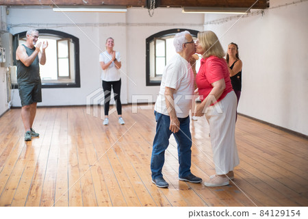 Caucasian retired couple kissing in dance studio 84129154