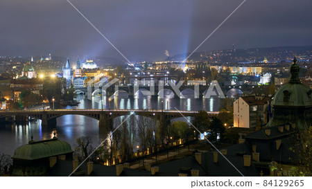 Panoramic view of the cityscape of Prague, Czech Republic, with the various bridges over Vltava River and the gothic architecture of the old town at night Panoramic view of the cityscape of Prague, Czech Republic, with the various bridges over Vltava River and the gothic architecture of the old town at night 84129265