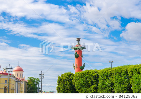 Rostral Column on Strelka Arrow of Vasilyevsky Island with green trees in Saint Petersburg Rostral Column on Strelka Arrow of Vasilyevsky Island with green trees in Saint Petersburg 84129362