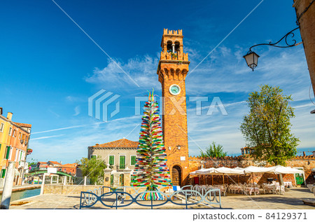 Murano clock tower Torre dell'Orologio of San Stefano church, Colorful christmas tree made of Murano Glass Murano clock tower Torre dell'Orologio of San Stefano church, Colorful christmas tree made of Murano Glass 84129371
