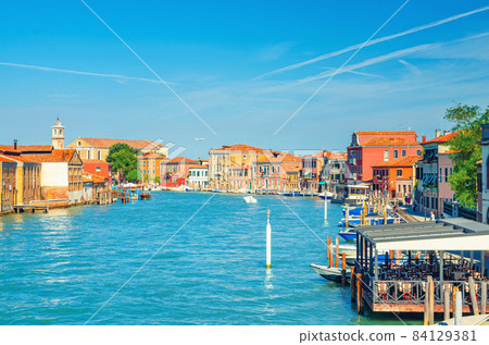 Murano islands water canal with Santa Maria degli Angeli church, boats and motor boats, Venetian Lagoon 84129381