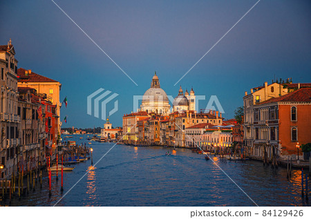 Venice cityscape with Grand Canal waterway. Buildings with evening lights along Grand Canal 84129426