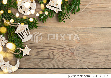 Hand made christmas decorations and christmas tree branches on a wooden table. Template for design in eco style, copy space Hand made christmas decorations and christmas tree branches on a wooden table. Template for design in eco style, copy space 84131084