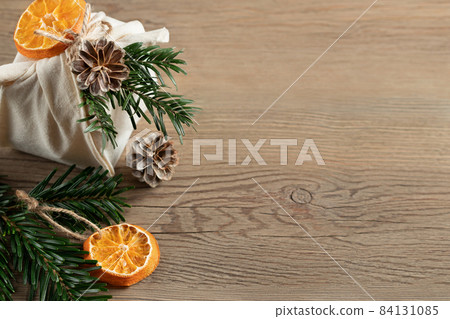 Zero waste christmas concept. Packed in natural fabric gift and decorations from natural materials on wooden table, top view, copy space Zero waste christmas concept. Packed in natural fabric gift and decorations from natural materials on wooden table, top view, copy space 84131085