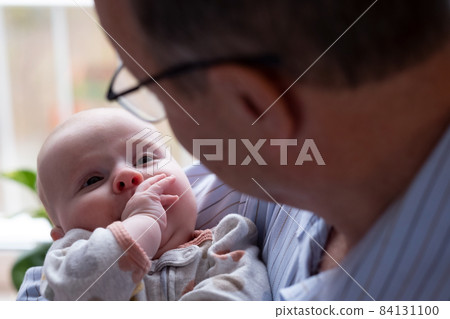 Grandfather holding a beautiful newborn baby girl 84131100