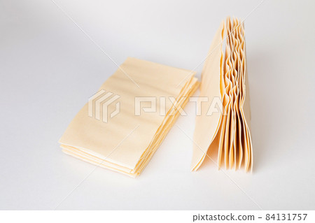 Raw lasagna. Dry dough sheets for lasagna on a white background. Raw lasagna. Dry dough sheets for lasagna on a white background. 84131757