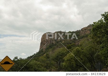 A Mountain Of Pink Granite And Bushland With Speed Bump Signage 84133629
