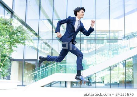Businessman jumping in front of an office building Shooting cooperation "LINK FOREST" 84135676