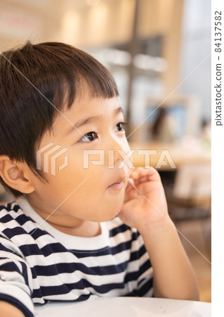 一個 4 歲的孩子在美食廣場吃飯時說話 一個 4 歲的孩子在美食廣場吃飯時說話 84137582