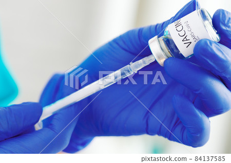 Doctor hands holding covid-19 vaccine preparing for vaccination of a patient Doctor hands holding covid-19 vaccine preparing for vaccination of a patient 84137585