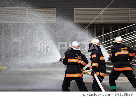 Fire extinguishing training by water discharge by firefighters 84138689