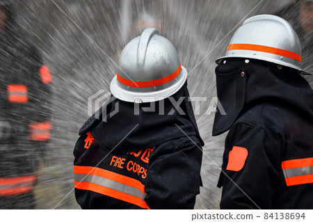 Fire extinguishing training by water discharge by firefighters Fire extinguishing training by water discharge by firefighters 84138694