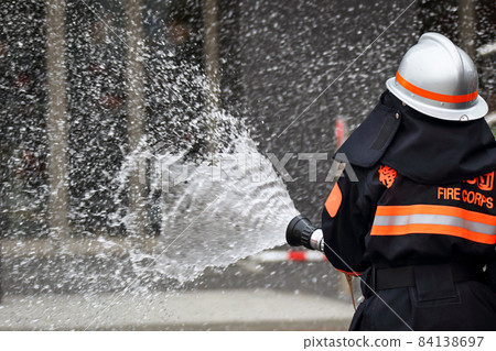 Fire extinguishing training by water discharge by firefighters 84138697