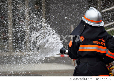 Fire extinguishing training by water discharge by firefighters 84138699