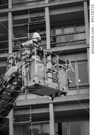 A firefighter who stretches a ladder to a building and conducts rescue operation training in a basket 84138728