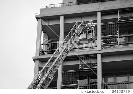 A firefighter who stretches a ladder and conducts rescue operation training in a basket 84138729