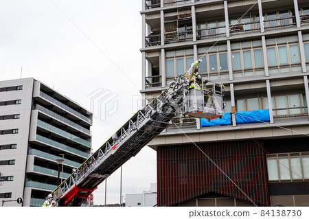 A firefighter who stretches a ladder and conducts rescue operation training in a basket 84138730