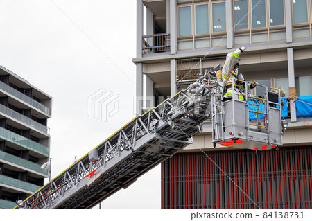 A firefighter who stretches a ladder and conducts rescue operation training in a basket 84138731