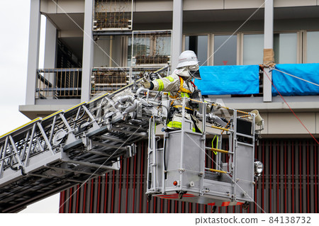 A firefighter who stretches a ladder and conducts rescue operation training in a basket 84138732