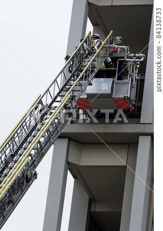 A firefighter who stretches a ladder and conducts rescue operation training in a basket 84138733