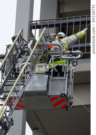 A firefighter who stretches a ladder and conducts rescue operation training in a basket 84138735