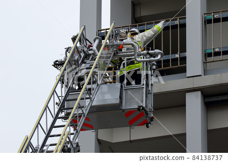 A firefighter who stretches a ladder and conducts rescue operation training in a basket 84138737